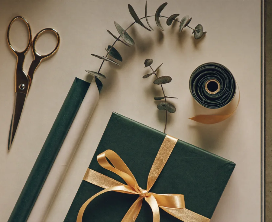 Scène éditoriale de cadeaux : emballage vert et ruban doré